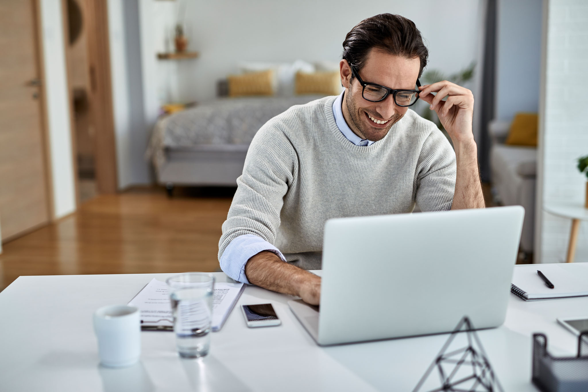 Glücklicher Teilnehmer eines Online-Meetings zu Hause am Computer.