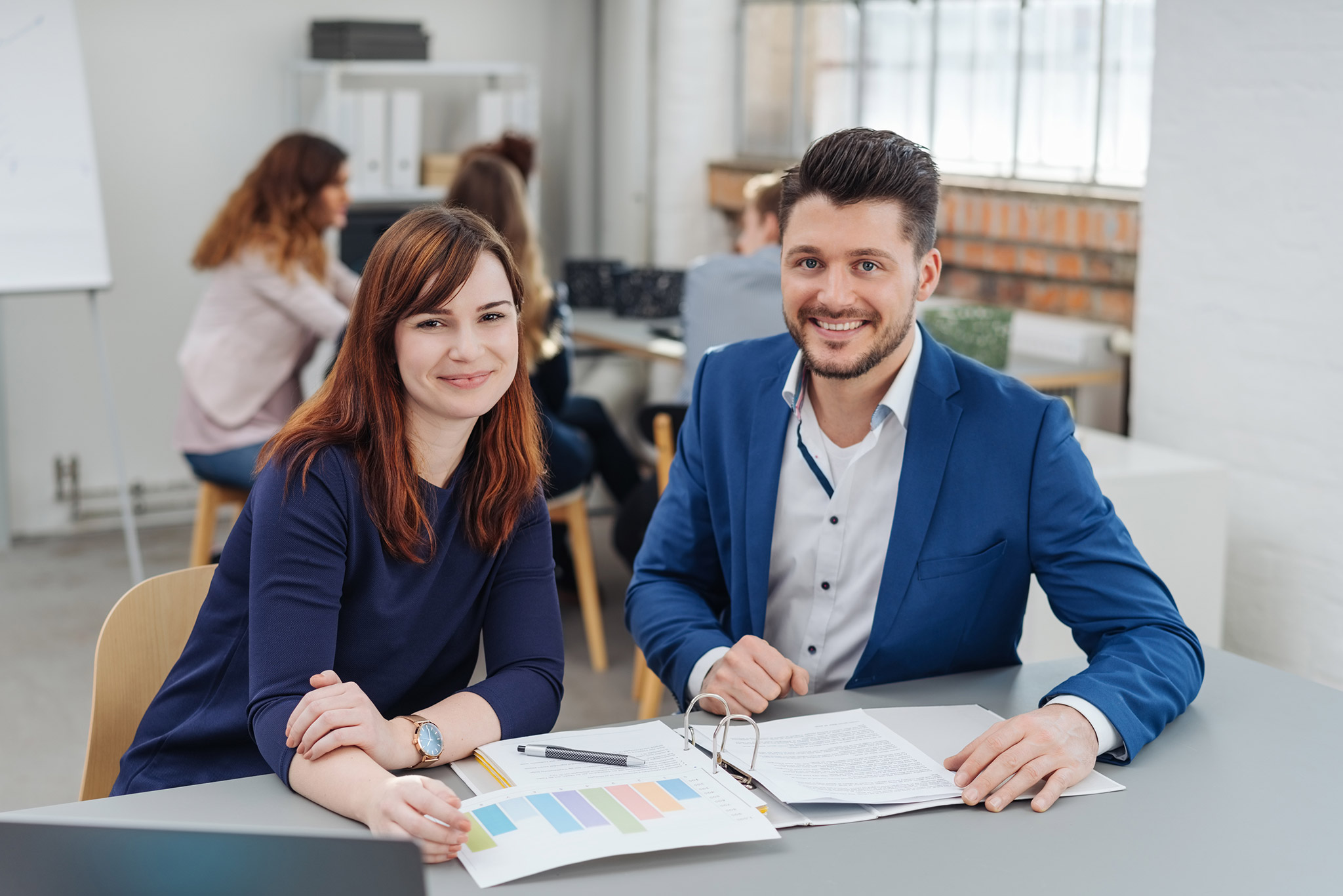 Junge Frau arbeitet mit einem Mann in einem Büro zusammen